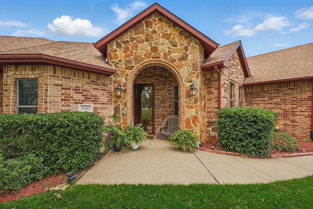 3241 Caleb Ct E, Midlothian, TX 76065 - doorway to property featuring brick siding, a shingled roof, and stone siding