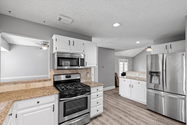 807 Fall Dr, Allen, TX 75002 - kitchen with stainless steel appliances, ceiling fan, a textured ceiling, backsplash, and white cabinetry