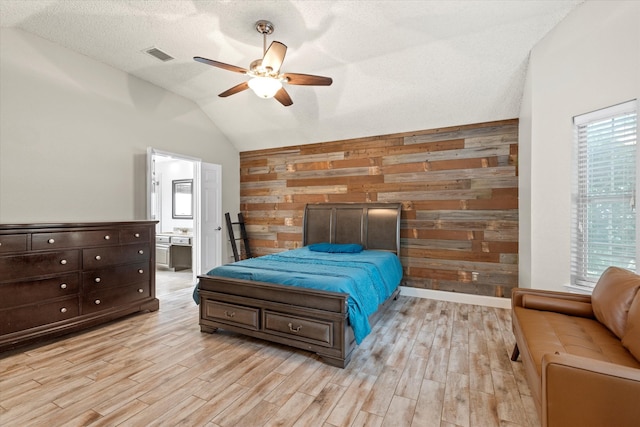 807 Fall Dr, Allen, TX 75002 - bedroom featuring vaulted ceiling, light wood-type flooring, wooden walls, ensuite bathroom, and a ceiling fan