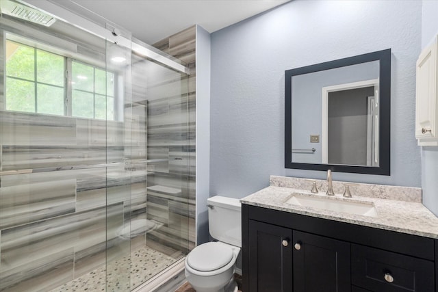 807 Fall Dr, Allen, TX 75002 - bathroom featuring toilet, vanity, a shower stall, and a textured wall