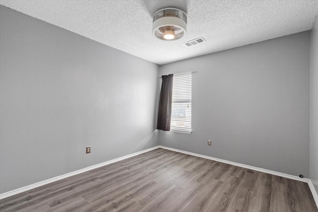 807 Fall Dr, Allen, TX 75002 - unfurnished room with wood finished floors, a textured ceiling, and baseboards