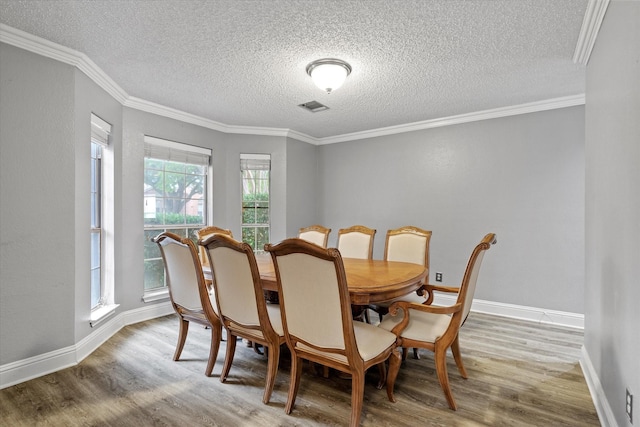 807 Fall Dr, Allen, TX 75002 - dining space featuring wood finished floors, a textured ceiling, baseboards, and crown molding