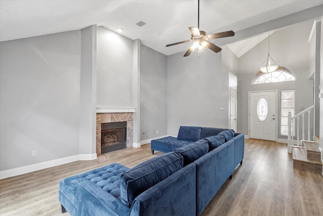 807 Fall Dr, Allen, TX 75002 - living room with stairs, high vaulted ceiling, ceiling fan, wood finished floors, and a high end fireplace