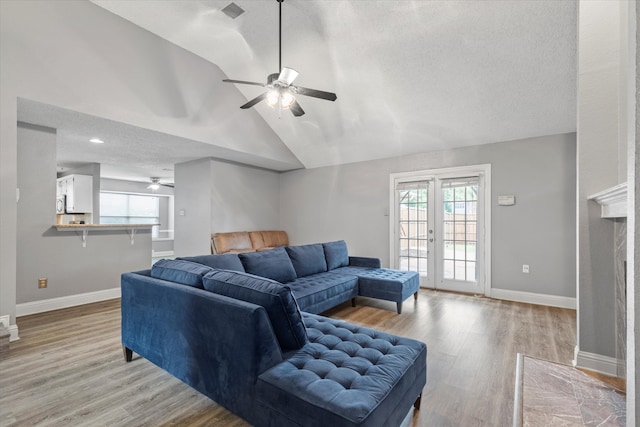 807 Fall Dr, Allen, TX 75002 - living area with a ceiling fan, vaulted ceiling, light wood-type flooring, baseboards, and a textured ceiling