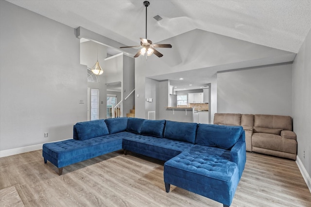 807 Fall Dr, Allen, TX 75002 - living area with ceiling fan, stairs, light wood-style floors, baseboards, and vaulted ceiling