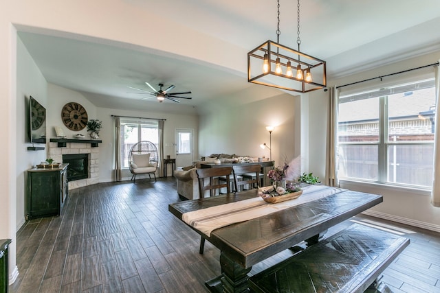 320 Lake Trail Ln, Prosper, TX 75078 - dining room with dark wood-style flooring, a ceiling fan, a stone fireplace, and baseboards