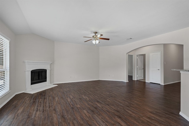 205 Mount Olive Ave, Mckinney, TX 75072 - unfurnished living room with ceiling fan, dark wood-style flooring, arched walkways, a fireplace, and vaulted ceiling