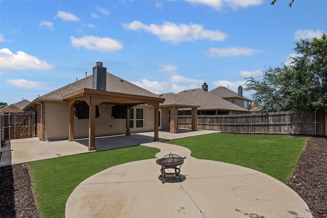 205 Mount Olive Ave, Mckinney, TX 75072 - back of property featuring a patio, brick siding, roof with shingles, an outdoor fire pit, and a chimney