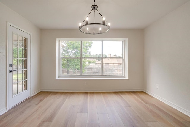 1177 Little Stone Ln, Burleson, TX 76028 - empty room featuring a chandelier, light wood-style flooring, and baseboards