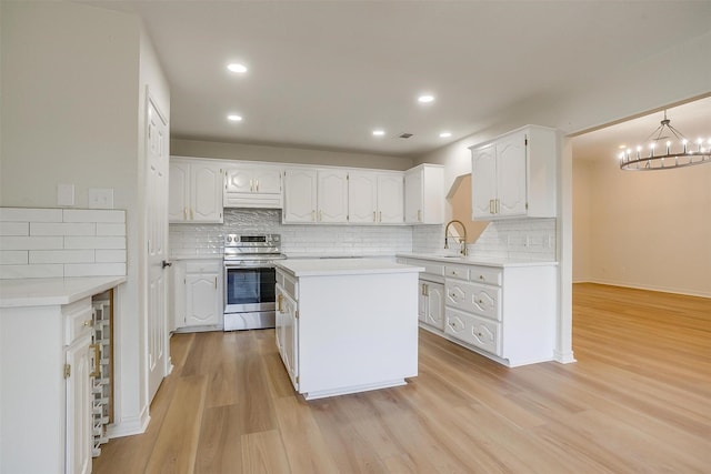 1177 Little Stone Ln, Burleson, TX 76028 - kitchen with electric range, white cabinetry, tasteful backsplash, light wood-style flooring, and light countertops