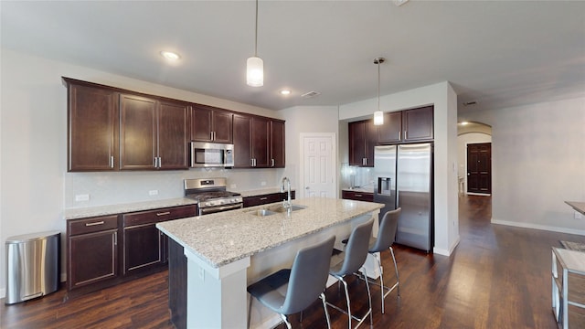1916 Prestige Cove Ct, Wylie, TX 75098 - kitchen with stainless steel appliances, a sink, dark wood-type flooring, arched walkways, and recessed lighting