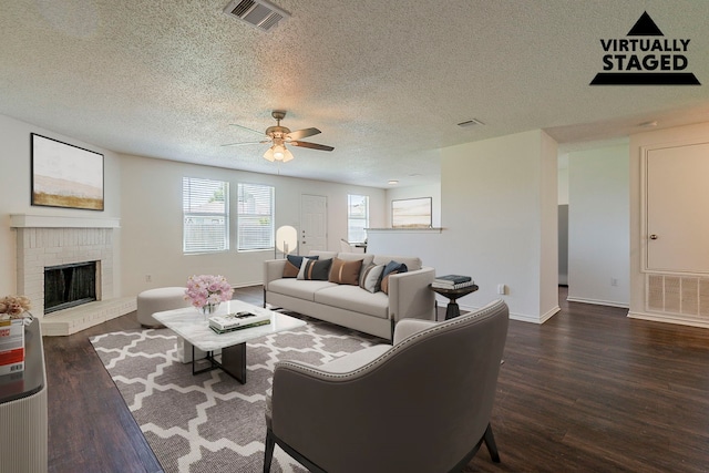 1423 Queen Annes Dr, Burleson, TX 76028 - living area with a ceiling fan, wood finished floors, a textured ceiling, baseboards, and a brick fireplace