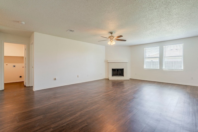 1423 Queen Annes Dr, Burleson, TX 76028 - unfurnished living room featuring a ceiling fan, dark wood-style flooring, a textured ceiling, a fireplace, and baseboards