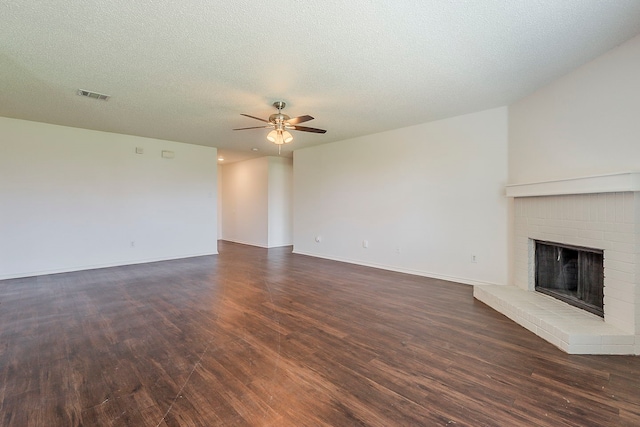 1423 Queen Annes Dr, Burleson, TX 76028 - unfurnished living room featuring ceiling fan, dark wood-style floors, a fireplace, baseboards, and a textured ceiling