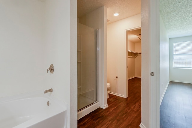 1423 Queen Annes Dr, Burleson, TX 76028 - bathroom with wood finished floors, a stall shower, toilet, a garden tub, and a spacious closet