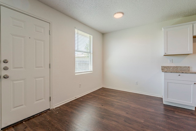 1423 Queen Annes Dr, Burleson, TX 76028 - unfurnished dining area with dark wood-style flooring, a textured ceiling, and baseboards