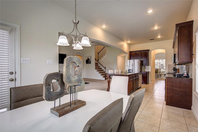1328 Sandpiper Dr, Forney, TX 75126 - dining area featuring arched walkways, a chandelier, light tile patterned floors, recessed lighting, and stairs