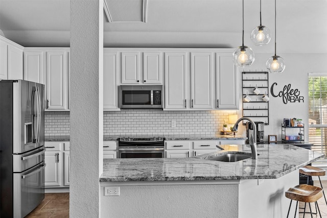 712 Saint Robby Dr, Mansfield, TX 76063 - kitchen featuring stainless steel appliances, a sink, tasteful backsplash, white cabinets, and a breakfast bar