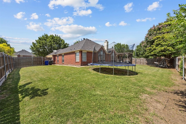 712 Saint Robby Dr, Mansfield, TX 76063 - rear view of house featuring a trampoline, brick siding, and a chimney