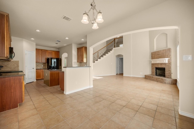 700 Sage Brush Dr, Weatherford, TX 76087 - kitchen with black appliances, open floor plan, light tile patterned floors, arched walkways, and recessed lighting