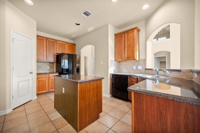 700 Sage Brush Dr, Weatherford, TX 76087 - kitchen featuring black appliances, a sink, arched walkways, tasteful backsplash, and a kitchen island