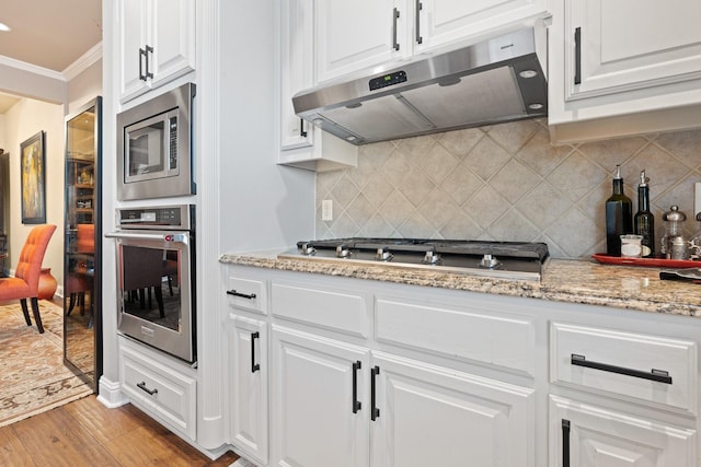 706 E 1st St, Fort Worth, TX 76102 - kitchen featuring stainless steel appliances, ventilation hood, crown molding, light wood-type flooring, and white cabinets