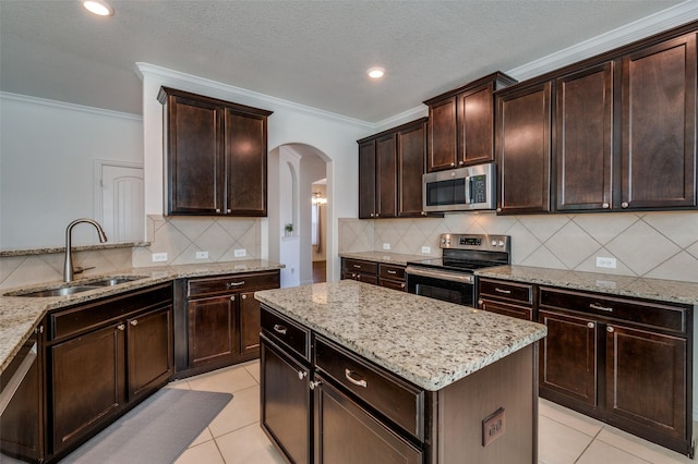 11812 Patton Dr, Frisco, TX 75036 - kitchen featuring stainless steel appliances, a sink, arched walkways, crown molding, and light stone countertops