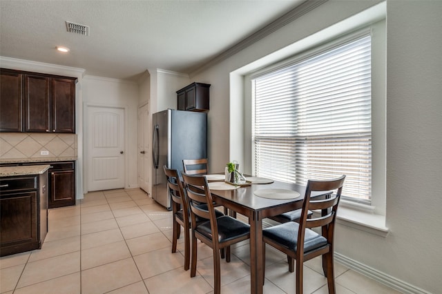 11812 Patton Dr, Frisco, TX 75036 - dining room with crown molding, light tile patterned floors, and baseboards