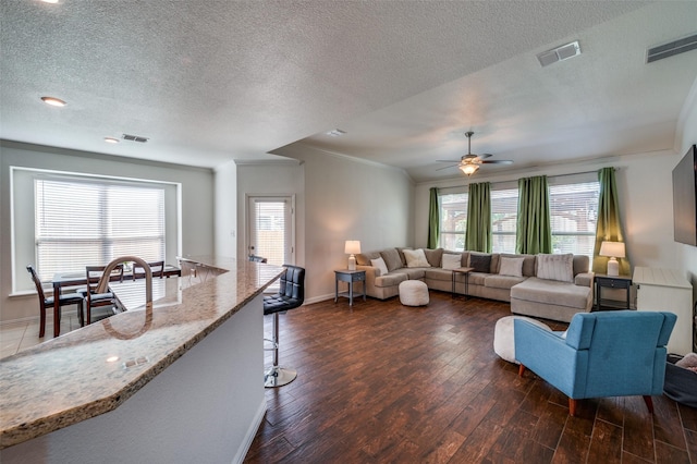 11812 Patton Dr, Frisco, TX 75036 - living room featuring dark wood finished floors, a ceiling fan, crown molding, plenty of natural light, and a textured ceiling