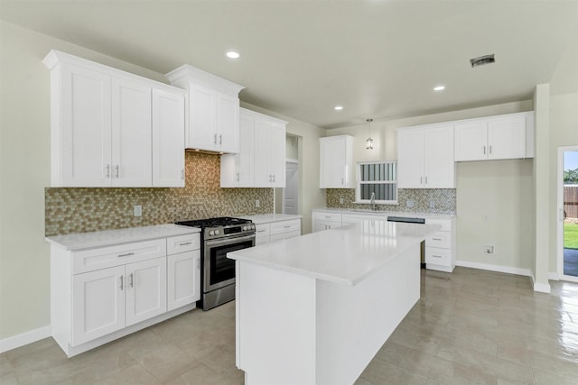548 Highview Ct, Godley, TX 76044 - kitchen with gas range, a center island, decorative backsplash, white cabinetry, and light countertops