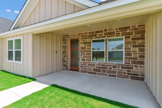 548 Highview Ct, Godley, TX 76044 - view of exterior entry featuring board and batten siding, roof with shingles, a patio, and brick siding