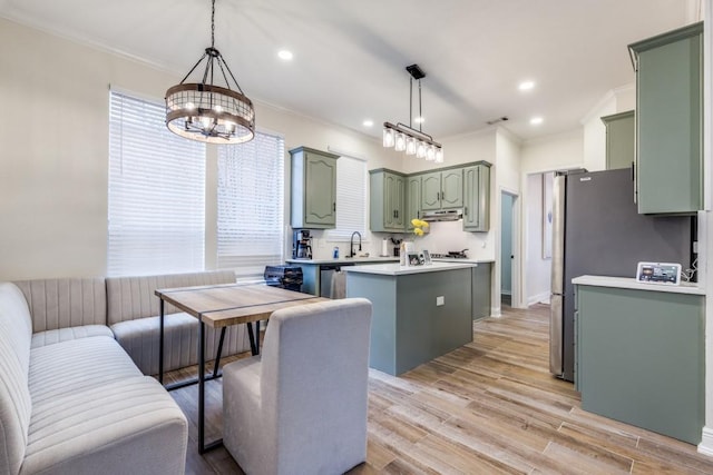 6637 Oakmont Ct, Plano, TX 75093 - kitchen with green cabinets, ornamental molding, a kitchen island, light countertops, and under cabinet range hood