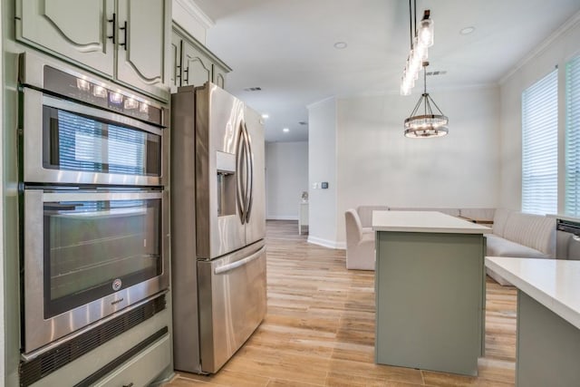 6637 Oakmont Ct, Plano, TX 75093 - kitchen featuring appliances with stainless steel finishes, hanging light fixtures, a kitchen island, light countertops, and light wood finished floors