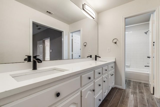 6637 Oakmont Ct, Plano, TX 75093 - full bathroom featuring double vanity, wood finished floors, and bathing tub / shower combination