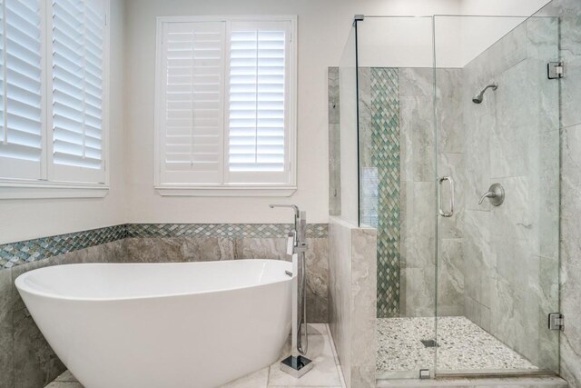 6637 Oakmont Ct, Plano, TX 75093 - bathroom featuring a freestanding bath, tile walls, a shower stall, and wainscoting