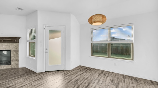 353 Paloma St, Weatherford, TX 76087 - unfurnished dining area featuring wood finished floors, a tiled fireplace, and baseboards
