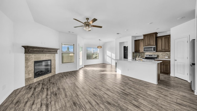 353 Paloma St, Weatherford, TX 76087 - unfurnished living room featuring ceiling fan, a sink, dark wood-type flooring, lofted ceiling, and a fireplace