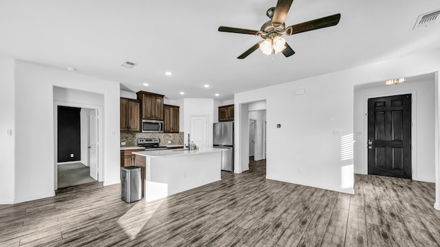 353 Paloma St, Weatherford, TX 76087 - kitchen with appliances with stainless steel finishes, light countertops, wood finished floors, a center island with sink, and recessed lighting