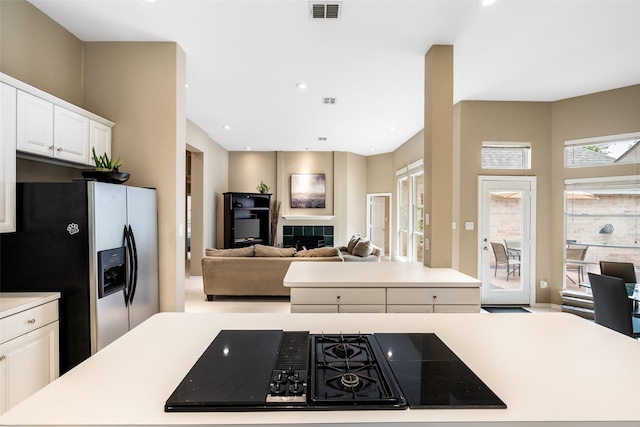 110 San Mateo Ct, Allen, TX 75013 - kitchen featuring stainless steel fridge, white cabinets, light countertops, stovetop with downdraft, and open floor plan