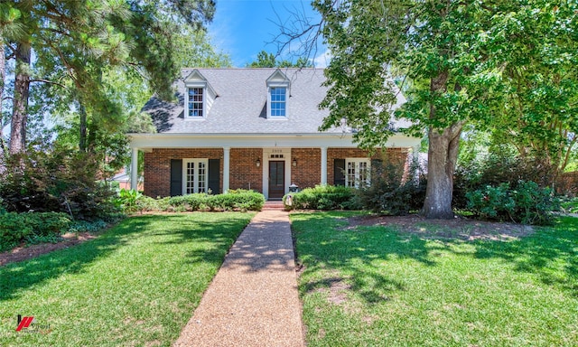 3909 Creswell Ave, Shreveport, LA 71106 - cape cod-style house with a front lawn, brick siding, roof with shingles, and french doors