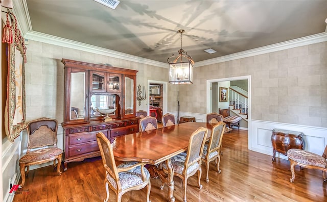 3909 Creswell Ave, Shreveport, LA 71106 - dining area with a chandelier, stairway, wood finished floors, and crown molding