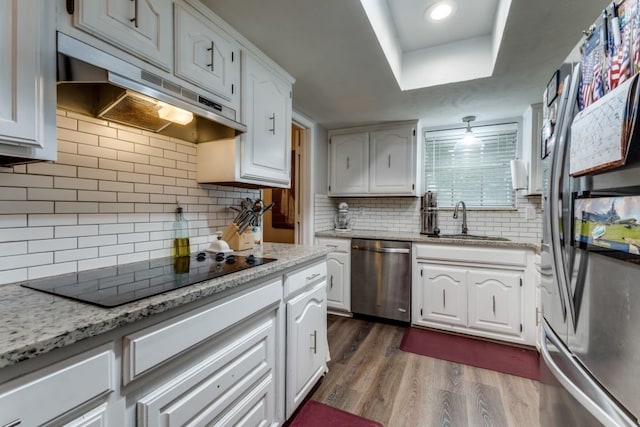 4937 Willowhaven Cir, Garland, TX 75043 - kitchen with stainless steel appliances, under cabinet range hood, a sink, dark wood-style flooring, and white cabinets