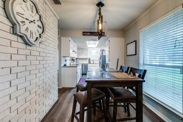 4937 Willowhaven Cir, Garland, TX 75043 - dining area featuring dark wood-style floors and brick wall