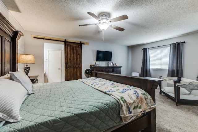 4937 Willowhaven Cir, Garland, TX 75043 - bedroom featuring carpet flooring, a barn door, a textured ceiling, and ceiling fan