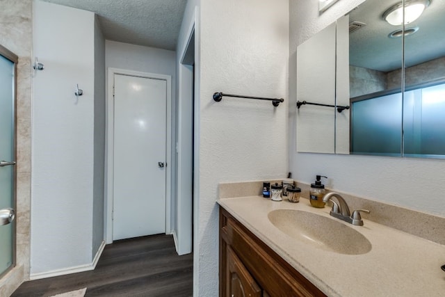 4937 Willowhaven Cir, Garland, TX 75043 - full bathroom with vanity, wood finished floors, a textured ceiling, and baseboards