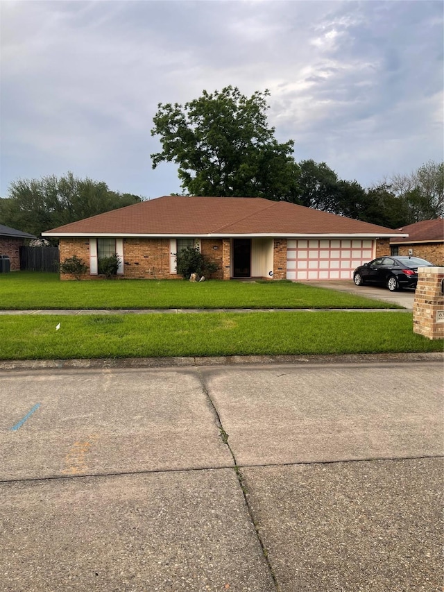6320 Bocage Dr, Shreveport, LA 71119 - view of front facade with a garage, a front yard, driveway, and central AC