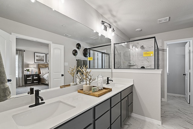 3701 Star Mesa Unit 14, Heartland, TX 75114 - ensuite bathroom with marble look tiles, double vanity, a shower stall, and baseboards