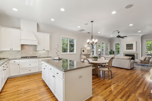 275 Casa Blanca Ave, Fort Worth, TX 76107 - kitchen with light wood-style floors, stainless steel gas stovetop, recessed lighting, a kitchen island, and a fireplace