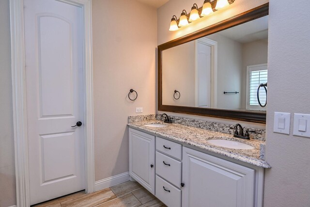 2230 Lewis Canyon Dr, Prosper, TX 75078 - full bathroom with double vanity, wood finished floors, and baseboards