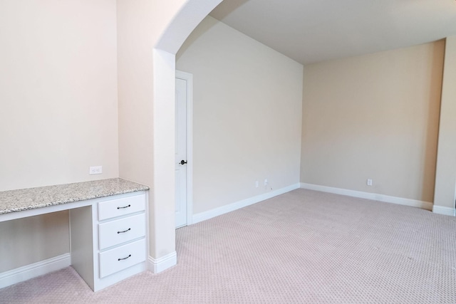 2230 Lewis Canyon Dr, Prosper, TX 75078 - unfurnished office with light carpet, built in desk, arched walkways, and baseboards
